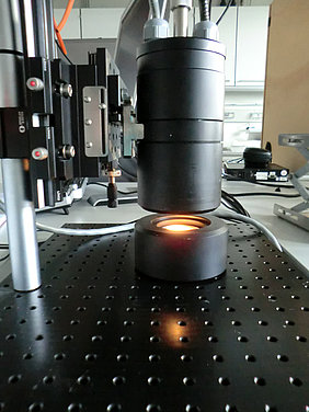Aufbau für die NIR-spektroskopische Analyse von HTC-Produkten in diffuser Reflexion. Der Messkopf ist mittels Glasfaser an das NIR-Spektrometer (nicht abgebildet) angeschlossen. Eine Messung benötigt weniger als eine Sekunde. (Foto: Fh-ICT)