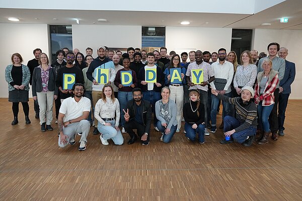 Group photo of the participants holding letters spelling out "PHDDAY".