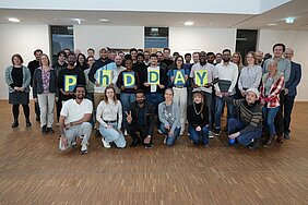 Group photo of the participants holding letters spelling out "PHDDAY".