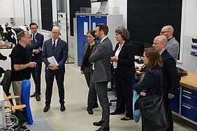 David Janke präsentiert seine Forschung vor der Delegation.